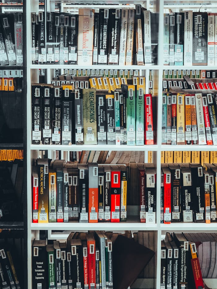A bookshelf filled with academic textbooks in a well-organized home library setting.